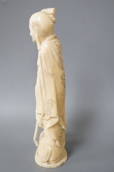 A Japanese carved walrus ivory figure of Fukurokuju, early 20th century,standing on the back of a tiger holding his staff, inset red seal mark to base, height 22cm